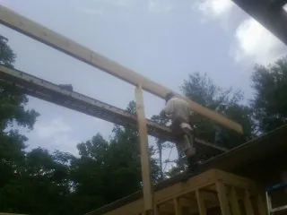 Carpenter setting a ridge beam over a new addition frame — Ice Dam Removal by Roofing Brothers in South Grafton